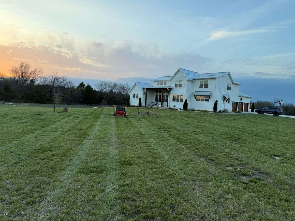 White farmhouse with a freshly mowed lawn at sunset