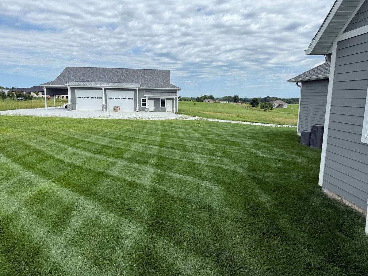 Detached garage with a boldly striped lawn